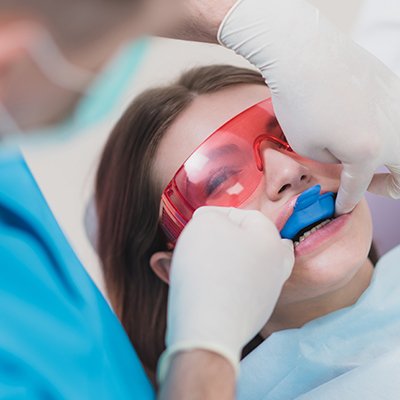 Dental patient receiving fluoride treatment to boost the impact of at home hygiene products