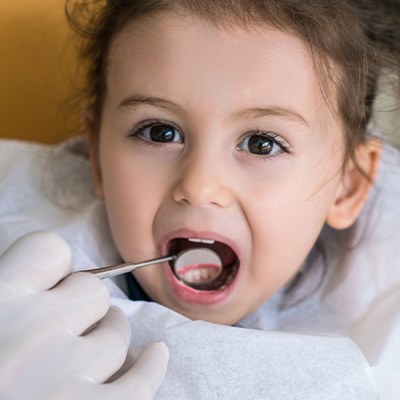 Dentist examining child's smile after tooth colored fillings