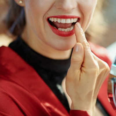 Woman pointing to dental crown 