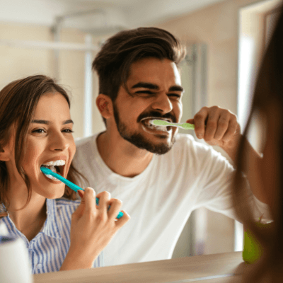 Man and woman brushing teeth to prevent dental emergencies