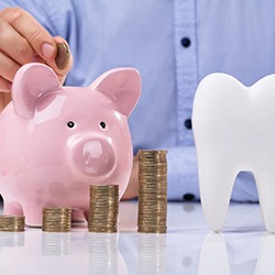 tooth and piggy bank for cost of dental implants in Rockwall  
