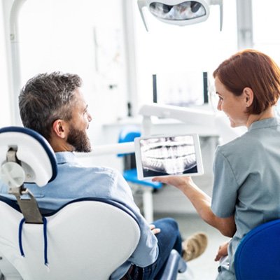 Dentist and dental implant candidate in Rockwall looking at X-ray