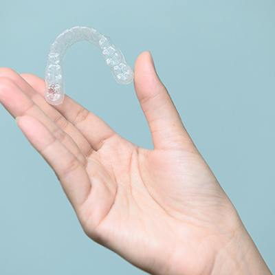 Patient holding Invisalign clear aligner