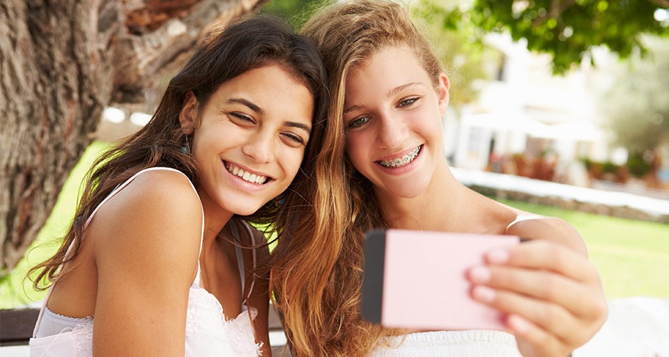 Two teens smiling during orthodontic treatment plans