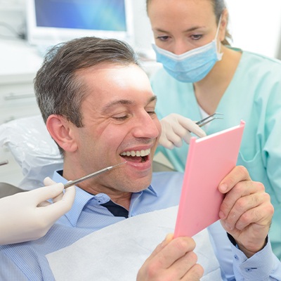 Man examining healthy smile after fluoride treatment