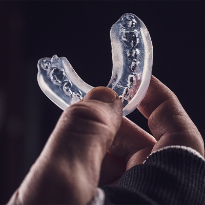 Dental patient holding an athletic mouthguard