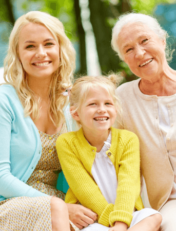 Three generations of women smiling after preventive dental services