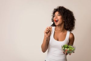 a woman eating healthy with veneers
